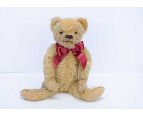 An Alpha Farnell teddy bear, circa 1930,  with golden mohair, clear and black glass eyes with remains of painted backs, prono