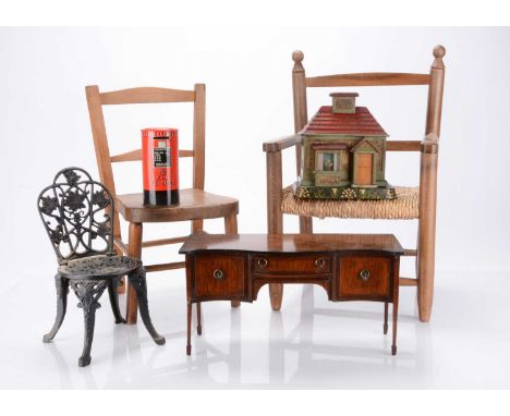 Two children's chairs,  one with rush seat —22 ¾in. (58cm.) high; a doll's sideboard; a wooden money box in the shape of hous