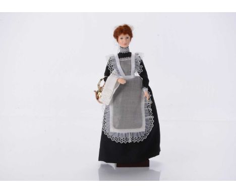 An Ann Parker artist doll modelled after a maid, cast polyester resin, with wired arms, holding a large kettle, on original b