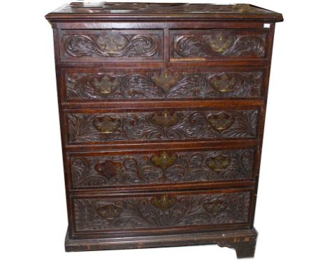 AN 18TH CENTURY OAK CHEST, with four long two short drawers, the doors are later carved with scrolling foliage and conforming