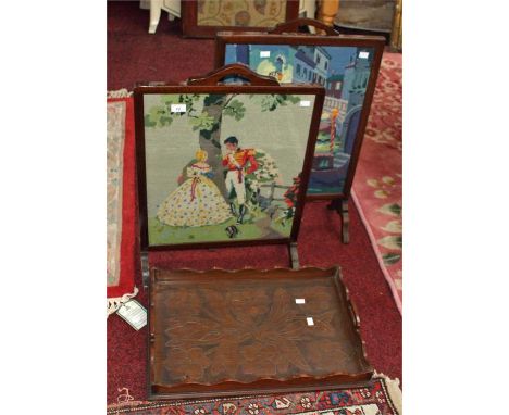 TWO SIMILAR CHEVAL FIRE SCREENS, each with tapestry panel; together with a carved two handled wooden tray with wavy edge, 23i