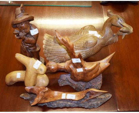 A COLLECTION OF MISCELLANEOUS CARVED WOODEN WORKS OF ART, comprising a young boy playing flute; another modelled with a goose