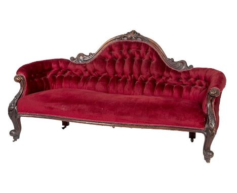 A VICTORIAN MAHOGANY SETTEE, the arched and button back with floral crest, above a serpentine fronted seat, raised on cabriol