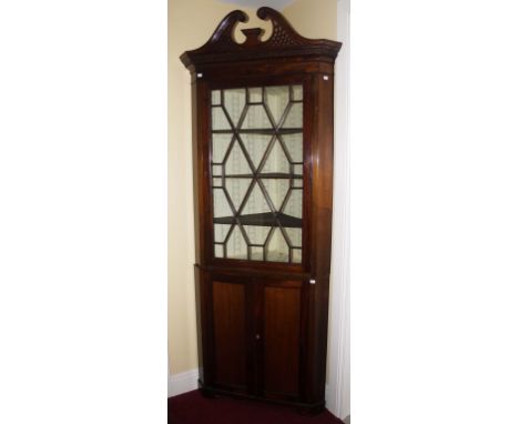 A MAHOGANY CORNER CABINET,  in the George III style, with fret cut swan neck pediment, and dentil moulded cornice and a singl