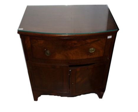 A BOW-FRONTED EBONY STRUNG MAHOGANY BEDSIDE COMMODE, adapted, now with a frieze drawer and two doors raised on splayed bracke