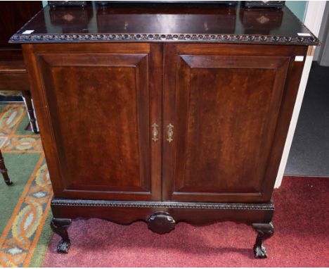 AN IRISH GEORGE III STYLE MAHOGANY TWO-DOOR CUPBOARD, the rectangular top moulded with an egg and dart band above two cushion