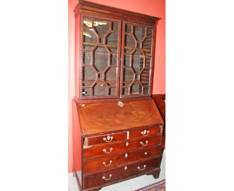 A GEORGIAN MAHOGANY SLOPE FRONT BUREAU BOOKCASE,  the associated top with a moulded cornice, above two astragal glazed doors,