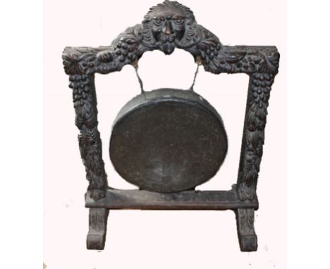 A 19TH CENTURY CARVED OAK HALL GONG, probably Irish,  with lion mask crest,  above an arch in a vine moulded frame and a circ