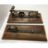 A pair of wall mounted brass gun racks w