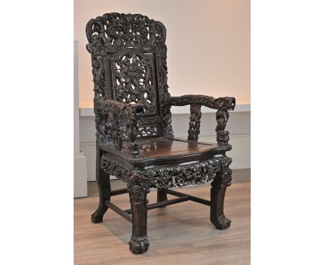 A CHINESE HARDWOOD ARMCHAIR, 19TH CENTURY. Heavily carved throughout with carved and pierced back rest with dragons and cloud