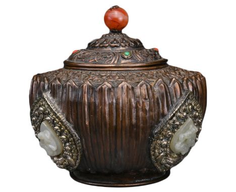 A TIBETAN COPPER REPOUSSÉ BOX AND COVER. The rounded lotus form body with jade 'dragon' emblems on splayed foot decorated to 