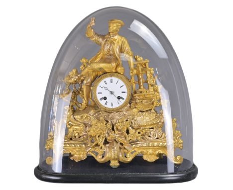 A FRENCH GILT METAL MANTEL CLOCK IN GLASS DOME, 19TH CENTURY. Man with cup and grape vines on ebonised stand. Clock height on