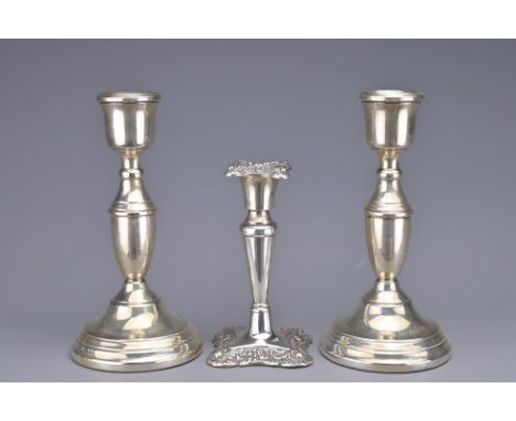 THREE SILVER HALLMARKED CANDLESTICKS. To include one pair inscribed from John and Joyce 1996 and one single candle stick with