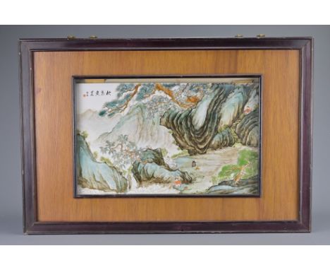 A CHINESE FRAMED PORCELAIN TILE, 20TH CENTURY. painted with scene of figures in landscape scene with calligraphy. Frame size.