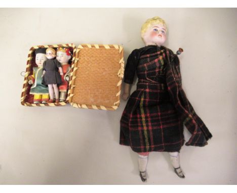 Three miniature bisque dolls, together with another bisque doll in Scottish costume Vosper 255 