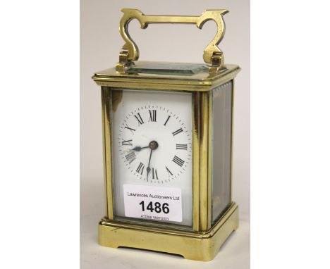 20th Century brass gilt cased carriage clock with enamel dial and Roman numerals (at fault), 12cms high 