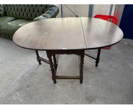 AN OAK DROP LEAF DINING TABLE ON BOBBIN TURNED SUPPORTS 