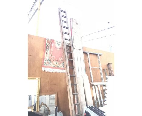 A THIRTY TWO RUNG WOODEN TWO SECTION LADDER 