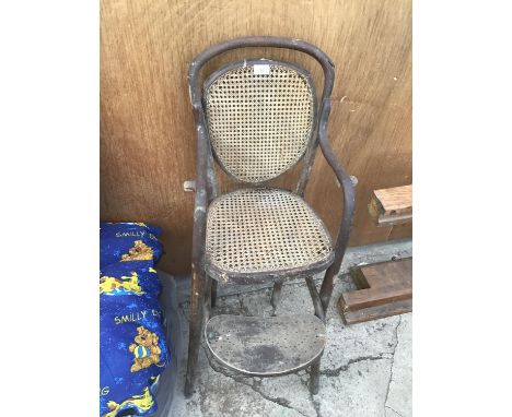 A VINTAGE WOOD AND RATTAN HIGHCHAIR 