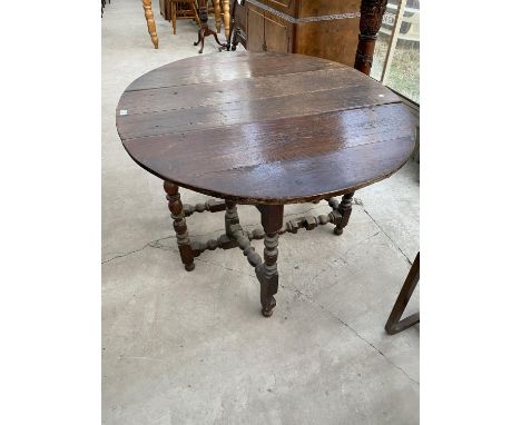 A GEORGIAN OVAL DROP LEAF OAK DINING TABLE ON BOBBIN TURNED SUPPORTS 