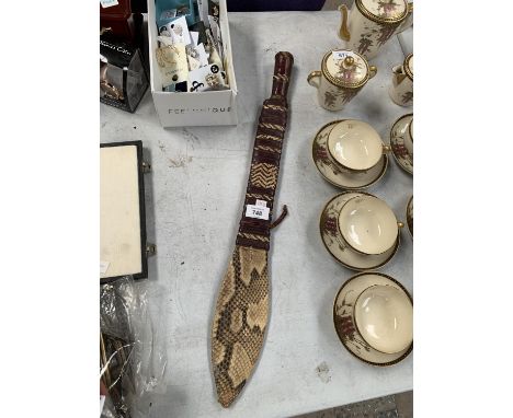 A TRIBAL LEATHER AND HANDLED SWORD WITH MATCHING LEATHER AND SNAKESKIN SCABBARD 