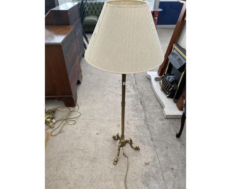 A BRASS STANDARD LAMP ON DECORATIVE TRIPOD SUPPORT 
