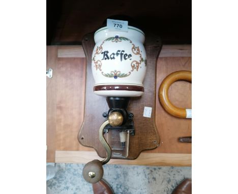 A VINTAGE CERAMIC COFFEE GRINDER ON WOODEN PLINTH 