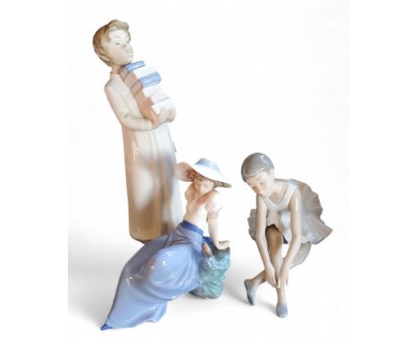 A Nao figure, of a boy with books, 28cm high, 233;&nbsp; others, ballerina, 13cm high;&nbsp; &nbsp;etc (3)