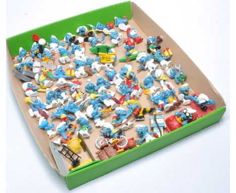 A collection of Smurf figures with associated accessories in addition to a small group of Wade ceramic figures. 