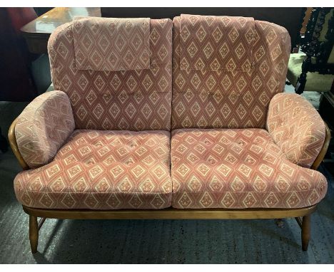 An Ercol beech and elm low two seater sofa, with square hoop and crossed stick back, with loose upholstered cushions, 143cm w