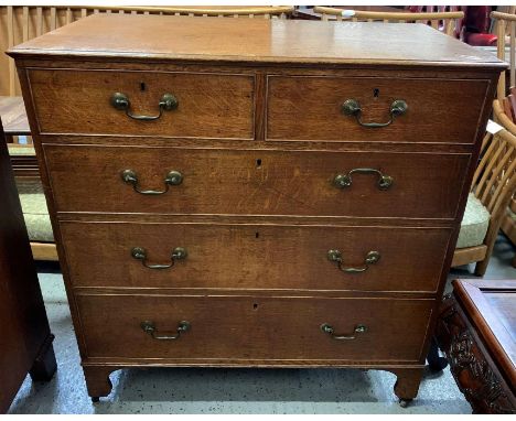 A Victorian oak chest of two short and three long drawers, with swing handles to each drawer, on bracket feet and later caste