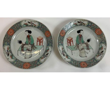 A pair of Chinese plates each decorated with a seated lady, with stylised border decorated with three birds, 21cm diameter