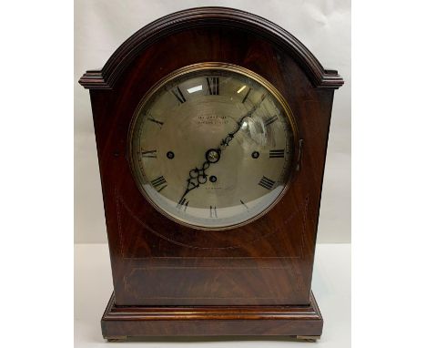 A continental (possibly German) arched mahogany cased mantle clock, with three train movement and striking on a gong, retaile