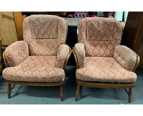 A pair of Ercol beech and elm low armchairs, with squared hoop and crossed stick back, original cushions, gold stickers to ba