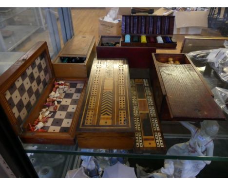 A mixed lot comprising three boxes with turned wooden chess pieces, two cribbage boards, a travelling chess set and a box of 