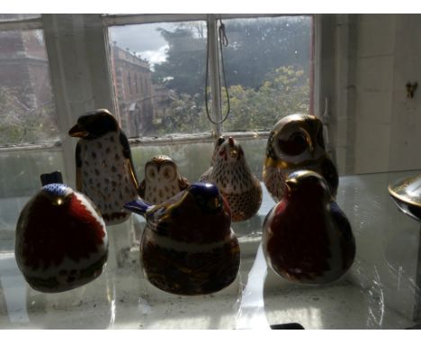 A collection of Royal Crown Derby paperweights, Christmas Robin, Bullfinch nesting, Robin, Rock Hopper Pengiun, Owlet, Hen an