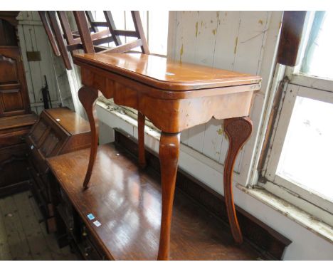 An early 20th Century light oak fold-over games table, raised on cabriole supports. 