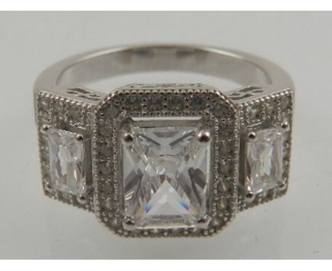 A silver and cubic zirconia triple cluster cocktail ring. 