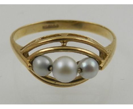 A 9 carat yellow gold and pearl ring, set three pearls in a double open mount. 