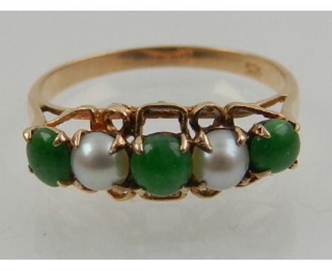 A 14 carat yellow gold, jade, and seed pearl ring. 