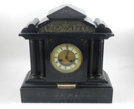 An early 20th century black slate mantle clock, the pediment incorporating a frieze above a dial flanked by columns, the base