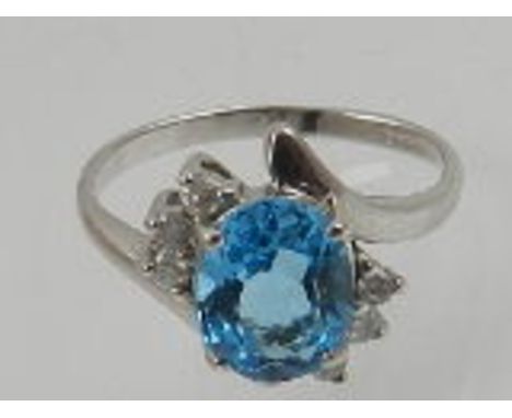 A 9 carat white gold, diamond, and blue topaz crossover style cluster ring. 