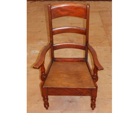 A Victorian fuitwood commode chair, possibly walnut, with a ladder back and later solid seat, 