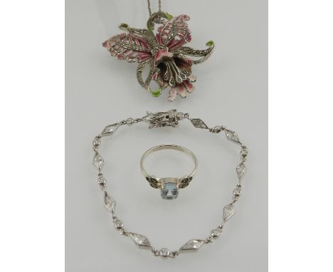 A white metal, marcasite, and enamel floral pendant, suspended on a white metal chain, together with a silver and blue topaz 