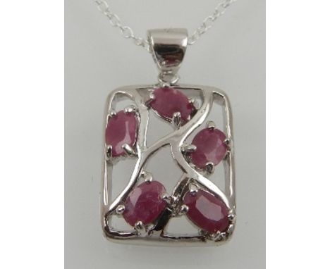 A silver and ruby pendant, of naturalistic design, suspended on a silver chain. 