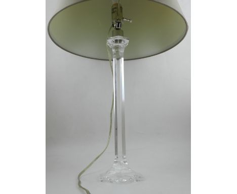 A crystal glass table lamp, having faceted stem and cream shade. H.70cm