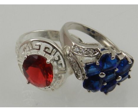 A pair of colourful cubic zirconia set costume cocktail rings, together with a white metal and red stone ring. (3)