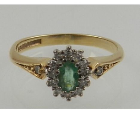 A 9 carat yellow gold, diamond, and emerald cluster ring. 