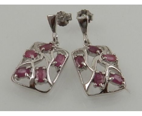 A pair of silver and ruby earrings of naturalistic design. 