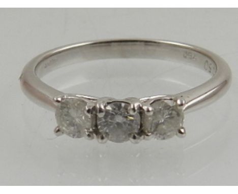 An 18 carat white gold and three stone diamond ring, the round cut stones of approx. 0.50 carats combined. 